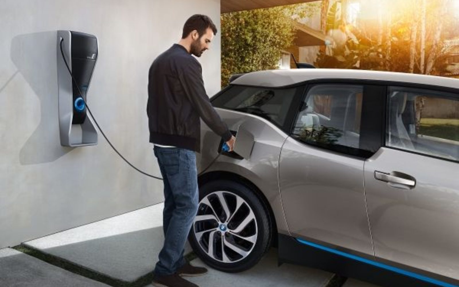 A man plugging in his electric vehicle